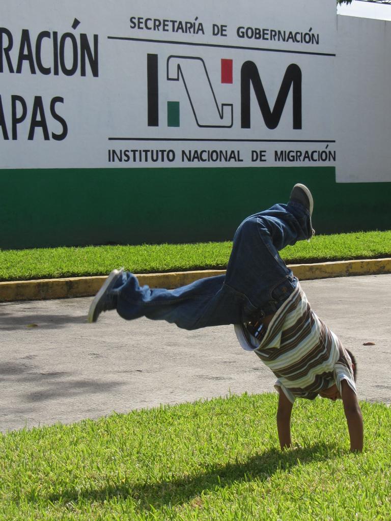 Ein honduranischer Junge übt Handstand vor dem größten Abschiebeknast Lateinamerikas in Tapachula. Von hier aus wurden im laufenden Jahr schon 10.000 Minderjährige abgeschoben, nachdem sie Wochen und Monate hinter Gittern verbracht hatten