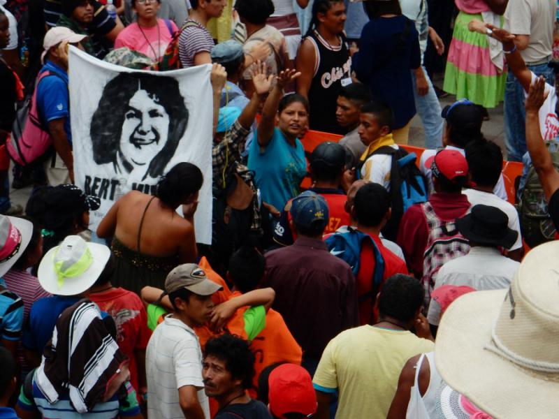 Demonstrierende versammeln sich mit dem Anlitz von Berta Cáceres. Als Studentin gründete sie den Rat der Indigenen und Volksorganisationen von Honduras (COPINH), der sich gegen Landraub, Abholzung, Bergbau und Geschlechtergewalt einsetzt
