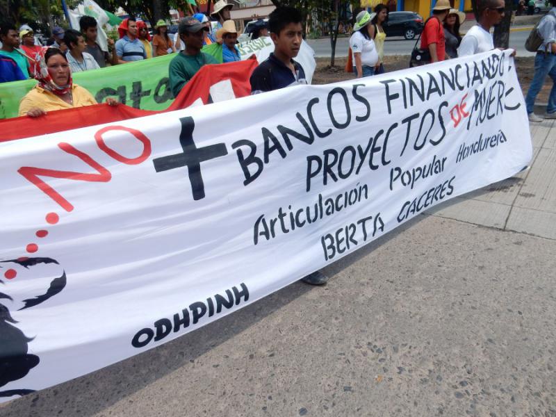 "Keine Banken mehr, die Projekte des Todes finanzieren". Die holländische Bank FMO und der finnländische FinnFund haben die Finanzierung des Agua Zarca-Staudammprojekts aufgrund des internationalen Drucks mittlerweile suspendiert