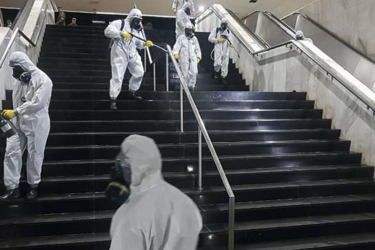 In Brasiliens Hauptstadt desinfizieren Soldaten den Busbahnhof. Währenddessen schüttelt Präsident Jair Bolsonaro woanders Hände.