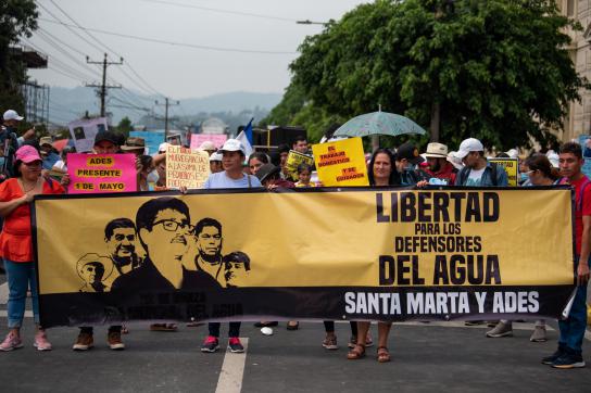 Die Gemeinde Santa Marta auf der 1.-Mai-Demonstration mit einem Transparent mit der Aufschrift "Freiheit für die Verteidiger des Wassers"
